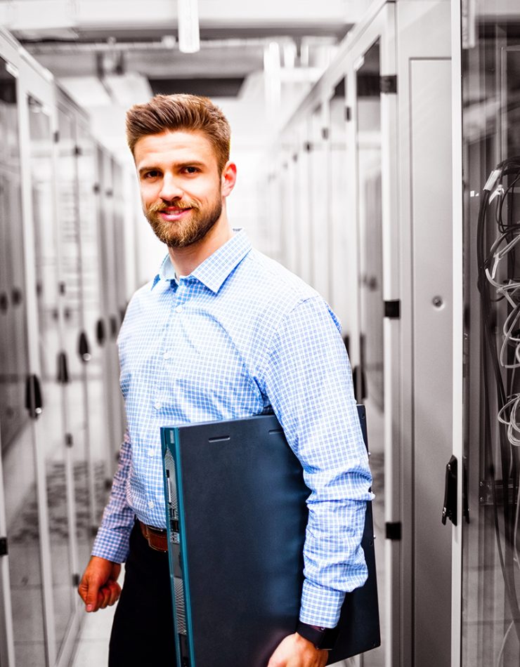 Portrait of technician holding a server in server room
